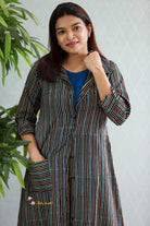 Woman wearing a striped kurta with a plain background-Thaliraambal